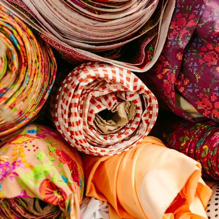 Fair trade aand ethical products Colourful rolls of patterned fabric in various textures and designs.